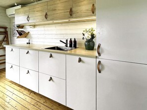 A kitchen with a wooden countertop, a sink, and cabinets with metal handles. - 4 Star Holiday Home in Uddevalla (Uddevalla)