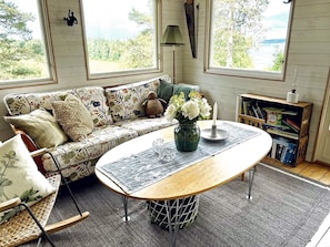 Uma sala de estar aconchegante com um sofá, uma mesa de centro e uma estante de livros.