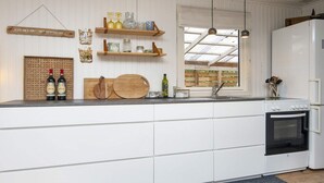 A modern kitchen with white cabinetry, wooden shelves, and a built-in oven. - 5 Person Holiday Home in Thyholm (Thyholm)