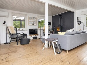 Una sala de estar acogedora con un sofá, sillones, un televisor y una chimenea.