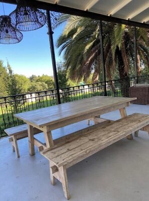 Enjoy al fresco dining on the patio surrounded by lush greenery and palm trees.