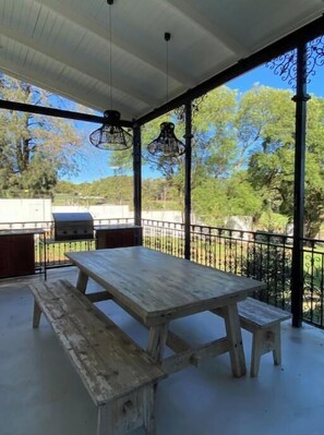 Enjoy al fresco dining with a barbecue grill and seating area surrounded by lush greenery.
