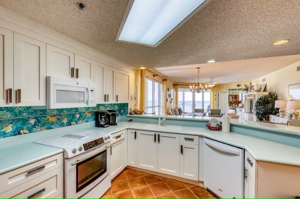 A kitchen with white cabinets, a microwave, a stove, and a dishwasher.