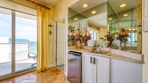 A modern kitchen with a dishwasher, a large mirror, and a view of the ocean through a sliding glass door. - Stunning Gulf front condo, shorter stays welcomed, great rates. (DESTIN)
