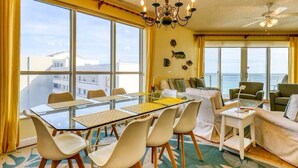 A room with a glass table and chairs, a sofa, and a ceiling fan. - Stunning Gulf front condo, shorter stays welcomed, great rates. (DESTIN)