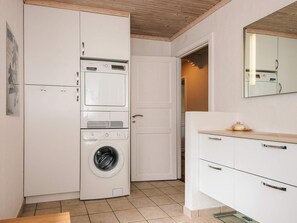 A compact laundry room with a washing machine, dryer, and stacked cabinets.