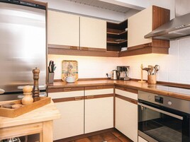 Una cocina con armarios de madera, cafetera y microondas.
