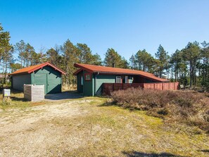 Two cabins with red roofs, a gravel path leading to them, and a forested background. - 4 Person Holiday Home in Thisted (Thisted)