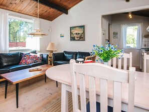 A cozy living room with a sofa, coffee table, and dining table.