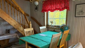 A dining area with a wooden table, chairs, and a staircase. - 7 Person Holiday Home in Tana (Tana)