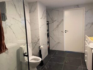 A bathroom with a toilet, a sink, and a shower area. - 6 Person Holiday Home in Bomlo (Bomlo)