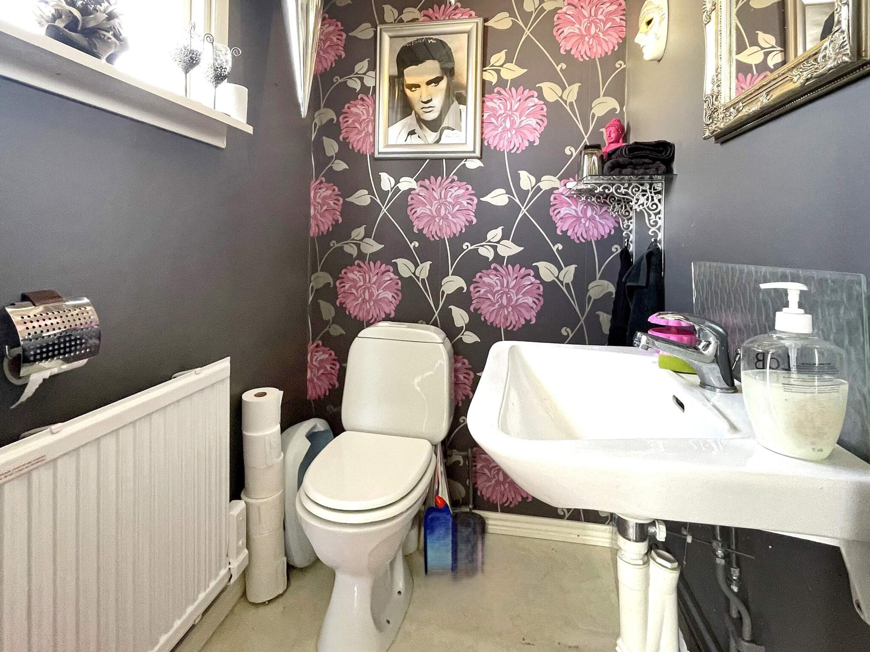 Un baño con inodoro, lavamanos y zona de ducha.