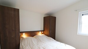Una camera da letto con un letto, un armadio in legno e una finestra.
