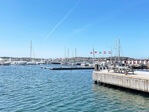A marina with boats docked, a wooden pier, and flags in the background. - 4 Star Holiday Home in Bohus (Bohus-Björkö)
