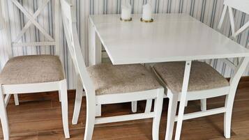 Una mesa de comedor blanca con tres sillas, cada una con un cojín.