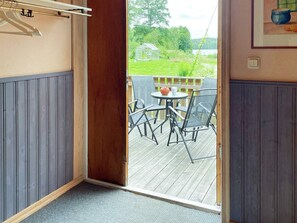 A room with a wooden door leading to an outdoor deck with a table and chairs. - 4 Star Holiday Home in Svangsta (Svangsta)