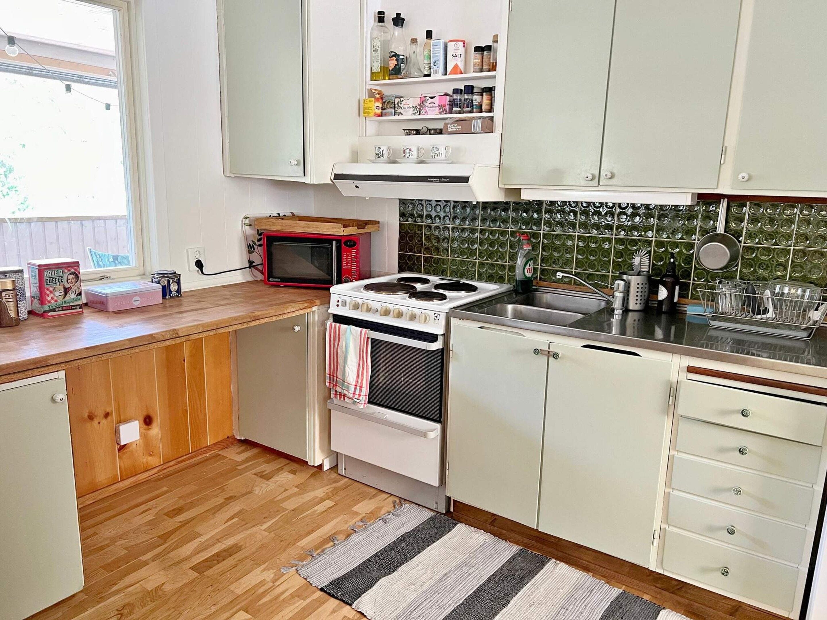 A kitchen with wooden cabinets, a microwave, a stove, and a tiled backsplash.