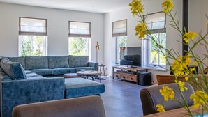 Una sala de estar moderna con un sofá modular, un televisor y una chimenea.