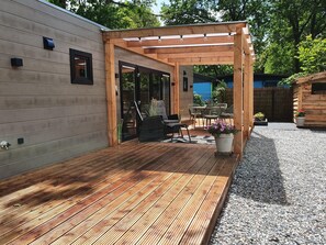 A wooden deck with a pergola, outdoor seating, and a gravel area. - Lodge in Hattemerbroek Near Veluwe Forest (Hattemerbroek)