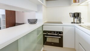 A modern kitchen with white cabinetry, a built-in oven, and a coffee maker. - Apartment in Middelkerke Near Sandy Beach (Middelkerke)