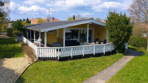Une maison de plain-pied dot ée d’un porche abrité, d’une petite terrasse et d’un jardin.