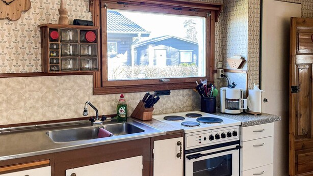 A kitchen with a window, a sink, a stove, and cabinets. - 5 Person Holiday Home in Solvesborg (Sölvesborg)