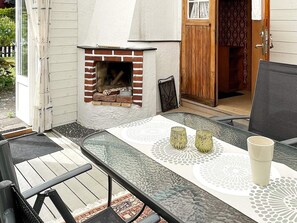 An outdoor patio with a glass table, two candles, and a white mug. - 5 Person Holiday Home in Solvesborg (Sölvesborg)