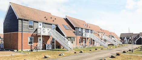 Una hilera de edificios de apartamentos modernos con escaleras externas que dan acceso a la entrada.