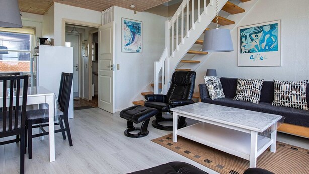 A modern living room with a staircase, a dining area, and a sofa set. - 5 Person Holiday Park Home in Borre (Borre)