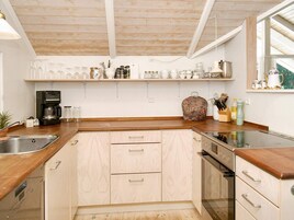 A kitchen with wooden cabinets, a coffee maker, and various kitchen utensils on the countertop.