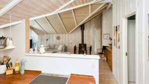 A compact kitchen with a central island, a built-in stove, and wooden flooring. - 6 Person Holiday Home in Graested (Graested)