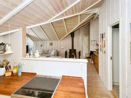 A compact kitchen with a central island, a built-in stove, and wooden flooring.