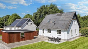 A two-story house with a sloped roof and solar panels on the roof. - 4 Star Holiday Home in Farso (Farso)