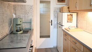 A kitchen with a coffee maker, a refrigerator, and a clock on the wall. - Vintage Style Apartment With Balcony/terrace (Bremen)
