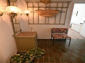 A room with a bed, a chair with floral upholstery, a hanging basket, and wall-mounted sconces. - Vintage Style Apartment With Balcony/terrace (Bremen)
