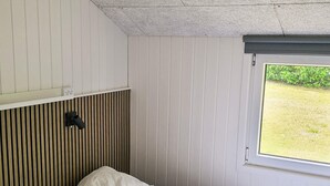 A single bed with white bedding in a room with white walls and a sloped ceiling. - 4 Star Holiday Home in Nordborg (Nordborg)