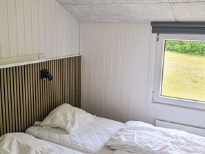 A single bed with white bedding in a room with white walls and a sloped ceiling. - 4 Star Holiday Home in Nordborg (Nordborg)