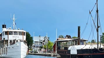 A marina with two boats docked, one named 'DIANA' and another with a white and red hull.