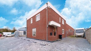A red brick building with a paved driveway and a gated entrance. - Cosy Apartment Near Center (Landgraaf)