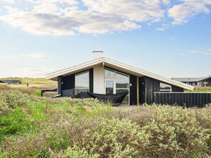 A modern house with a sloped roof, large windows, and a black exterior. - 4 Star Holiday Home in Lokken (Lokken)