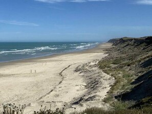 A beach with a clear sky, a sandy shore, and a rocky cliff. - 4 Star Holiday Home in Lokken (Lokken)