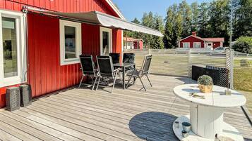 A red building with a covered patio area featuring a table and chairs.