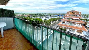 Un balcón con vista a un puerto deportivo y edificios.