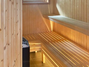 A sauna with wooden benches and a sloped ceiling. - 4 Star Holiday Home in Ljustero (Ljusterö)