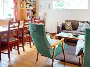 A cozy living room with a dining area, wooden furniture, and a bookshelf. - 4 Star Holiday Home in Osby (Osby)