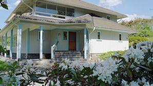 A two-story house with a porch, a front door, and a staircase leading to the entrance. - 4 Star Holiday Home in Hamburgsund (Hamburgsund)