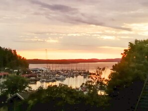 A marina with boats docked, surrounded by trees and a body of water. - 4 Star Holiday Home in Myggenas (Myggenäs)