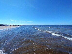 Ein Strand mit blauem Himmel und ruhigem Wasser.