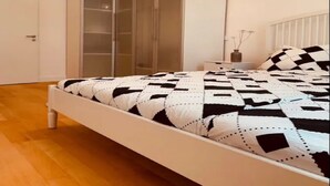Une chambre à coucher avec un lit, une armoire et une table de chevet.