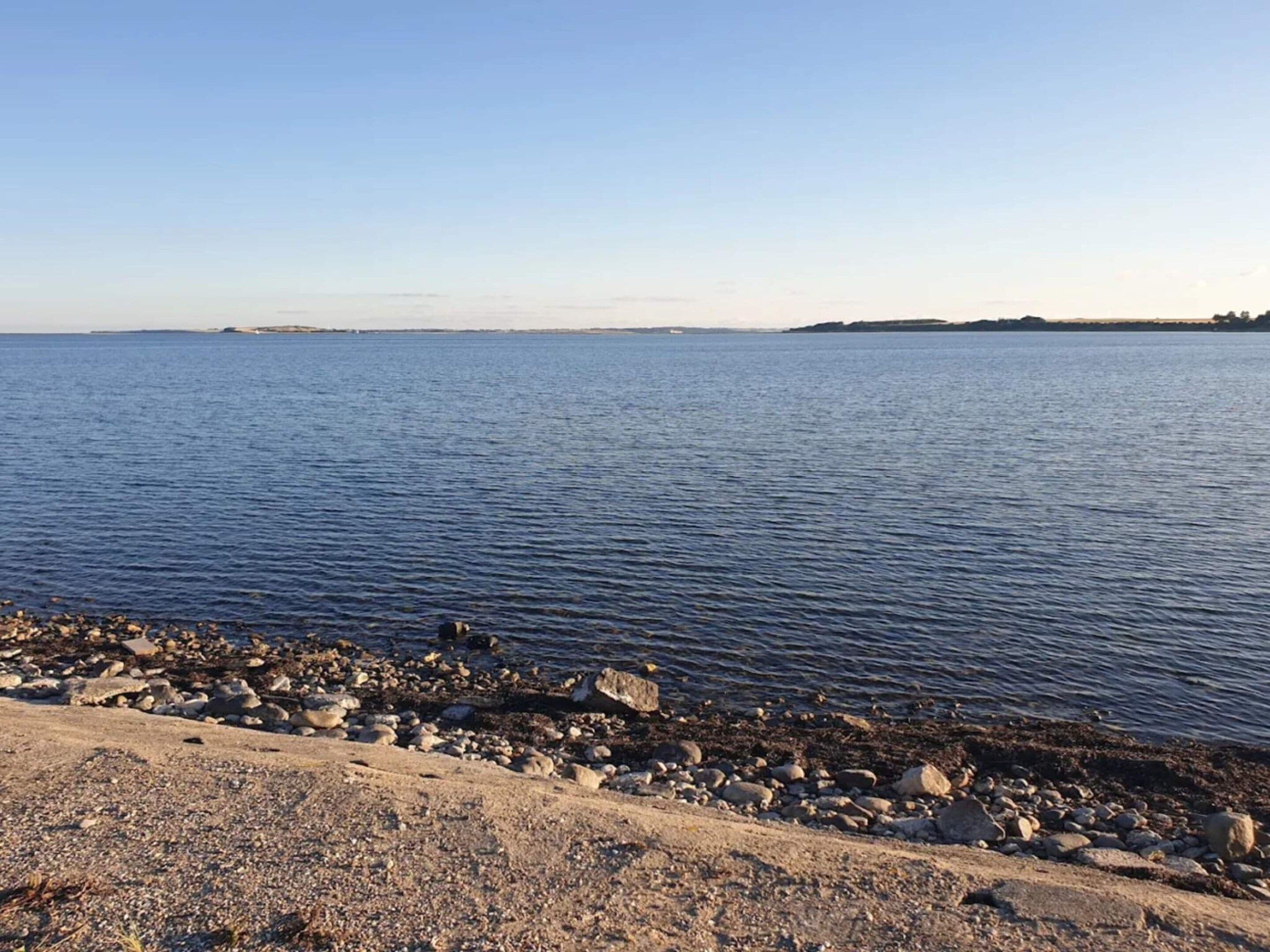 A calm body of water with a rocky shoreline.